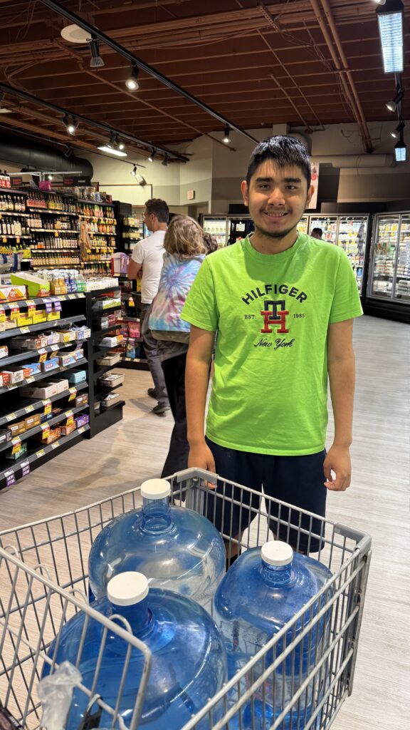 Young guy filling up with FreshPure Waters at Earth Fare, Asheville.